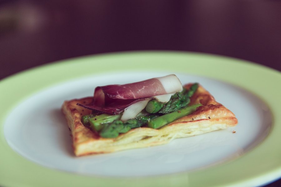 Un feuilleté d’asperges vertes et de jambon cru sur une assiette