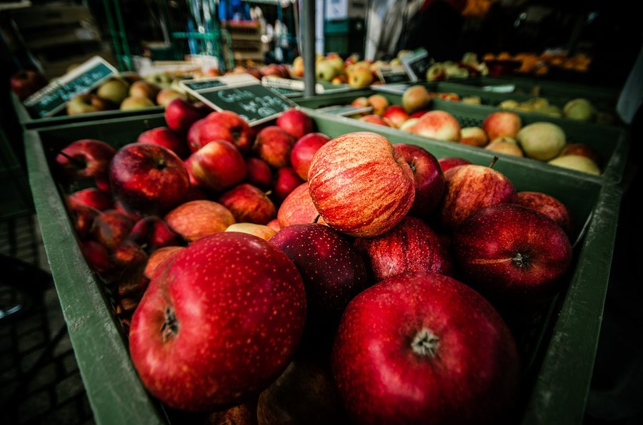 Des cagettes de pommes rouges sur un étal de marché